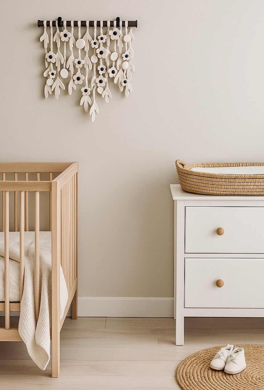 Nursery room with wooden crib, white dresser, and decorative wall hanging.