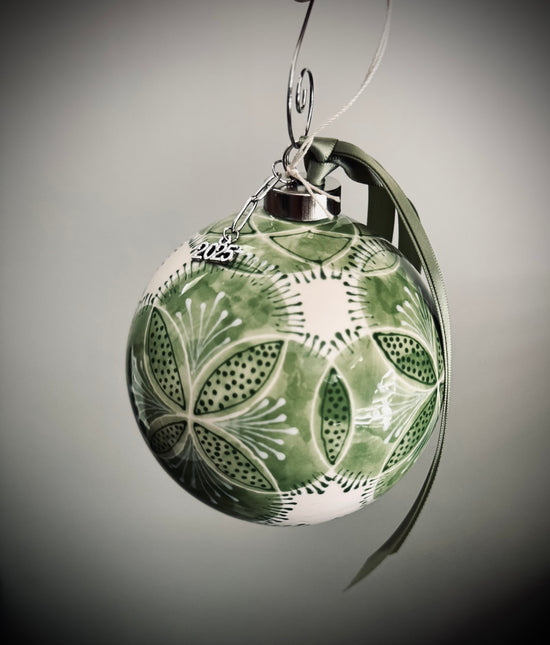 Decorative green ornament with floral patterns on a gray background