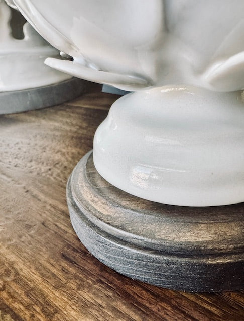 White ceramic urns on wooden stands