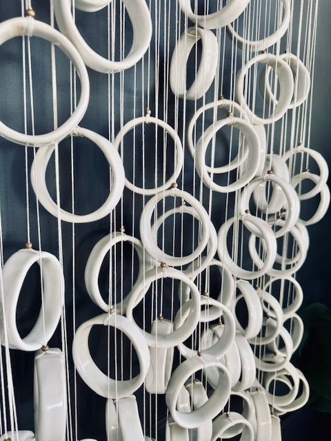 White circular hanging decorations against a dark background