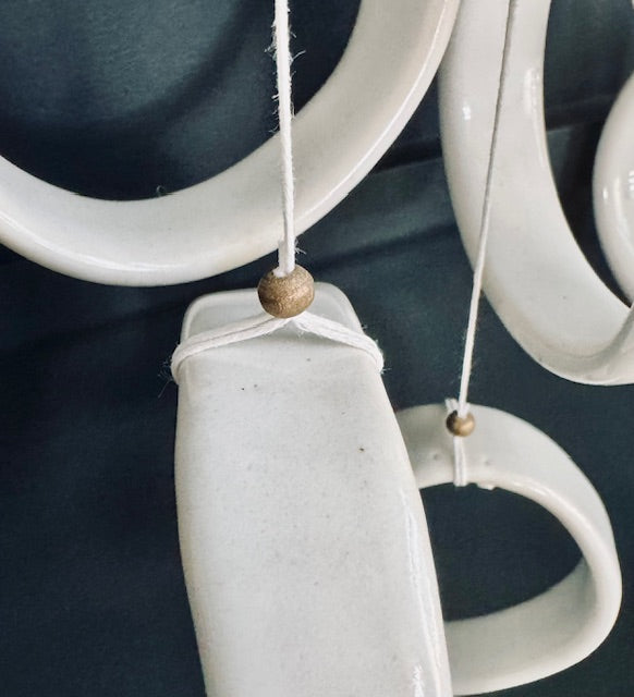 Close-up of a ceramic wall hanging with circular designs on a dark background