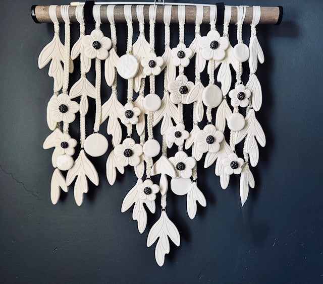 Decorative wall hanging with white floral patterns on a dark background