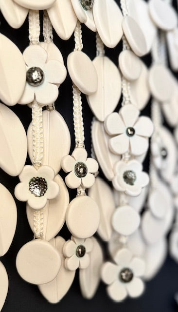 Close-up of decorative white flowers with black centers on a dark background