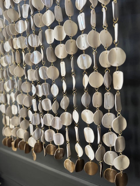 Decorative string of round, oval, and teardrop-shaped beads with gold accents on a dark background.