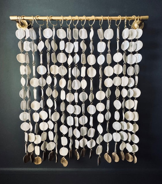 Decorative curtain made of circular ceramic discs on a dark background